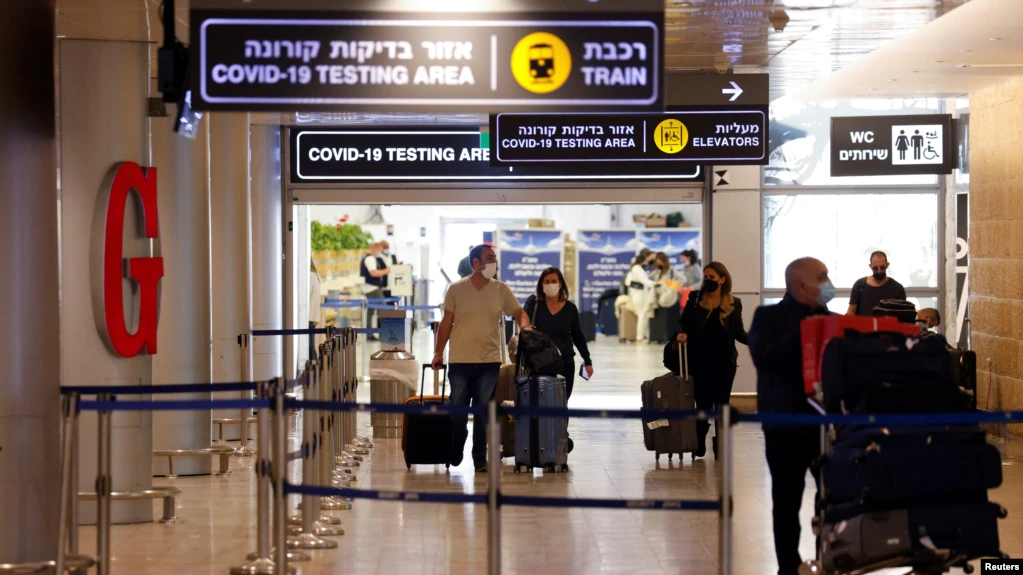 Los viajeros salen del área de prueba de coronavirus en el Aeropuerto Internacional Ben Gurion